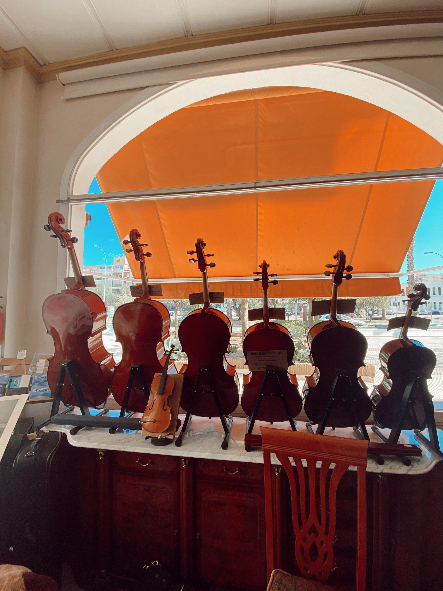 The Dennis Braun shop window lined with cellos and violins in natural light