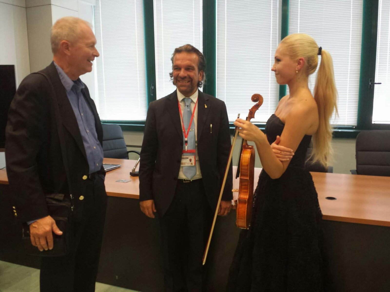 Dennis Braun meeting with a concert violinist who is holding her instrument and bow
